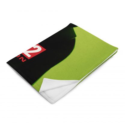 Folded throw blanket showing lime green design of Zalika from Evil Genius 2