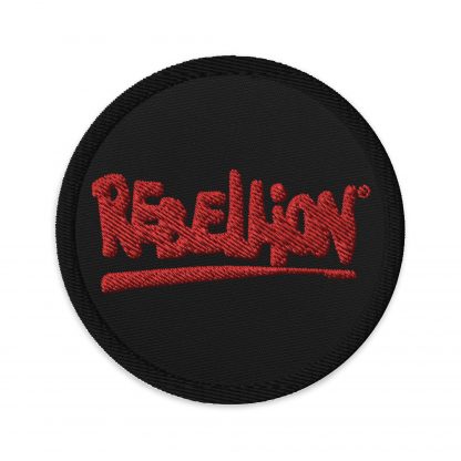 A black circular embroidered patch with Rebellion logo in red
