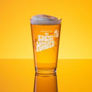 Amber lit image of a full foamy pint glass with the words 