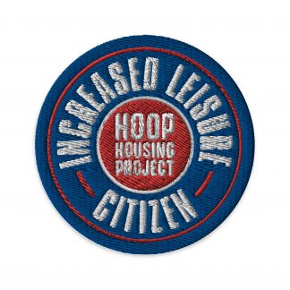 An embroidered patch with "Increased Leisure Citizen - Hoop Housing Project" in white writing on a blue and red background